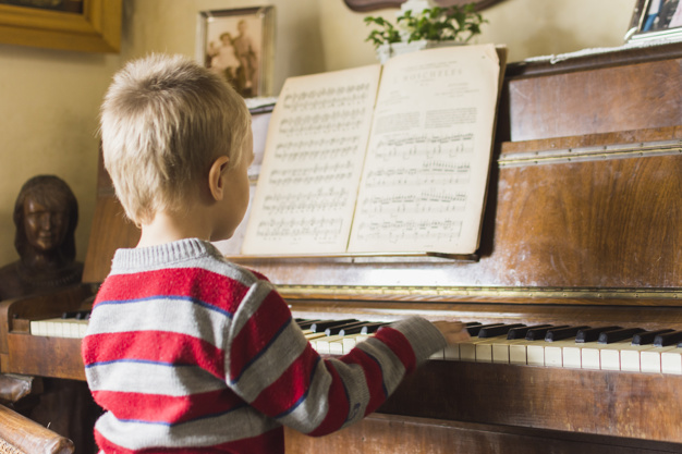 blonde boy playing piano at home 23 2147873697 - Aprendendo sobre Partituras: Orientações para o seu aprendizado!